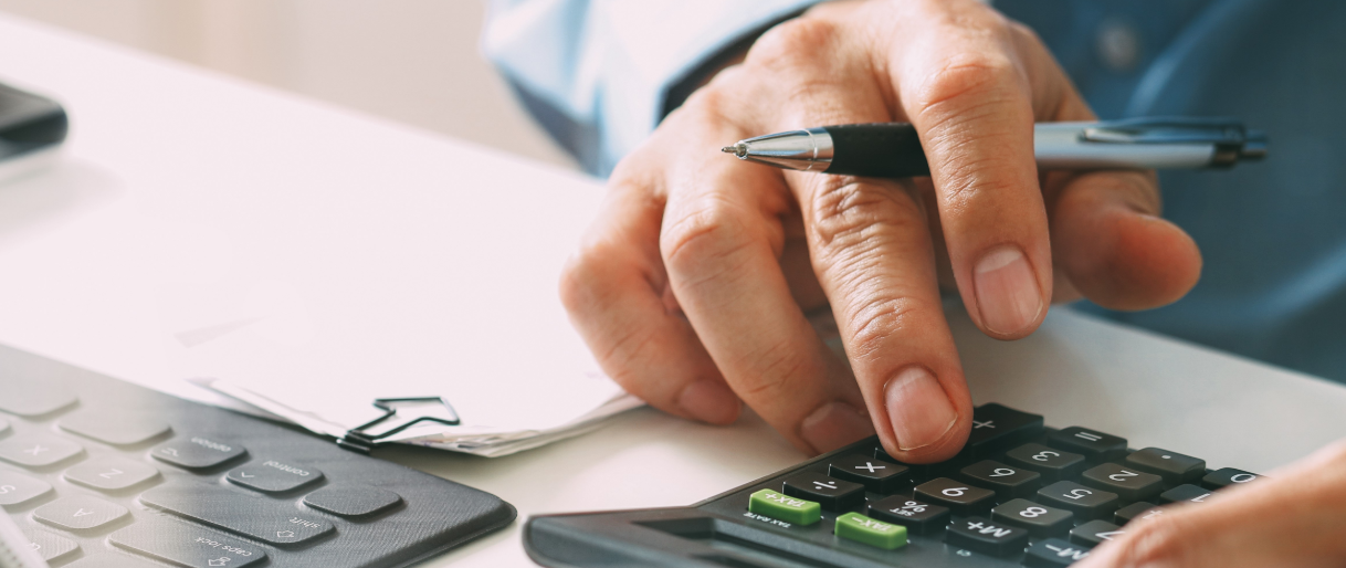 Business person using a calculator and keyboard